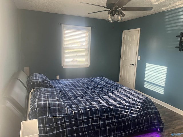 bedroom featuring ceiling fan, hardwood / wood-style floors, and a textured ceiling