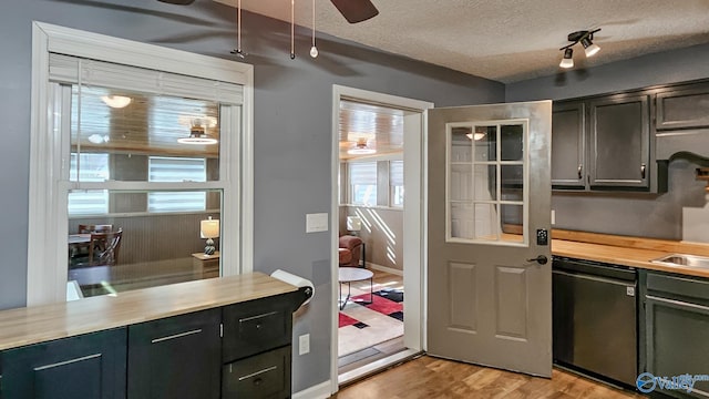 kitchen with ceiling fan, a textured ceiling, light hardwood / wood-style flooring, and black dishwasher