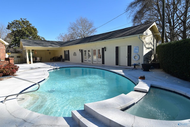 view of swimming pool with a pool with connected hot tub, a patio, and french doors