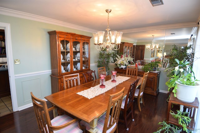 dining area with dark wood-style floors, wainscoting, visible vents, and an inviting chandelier