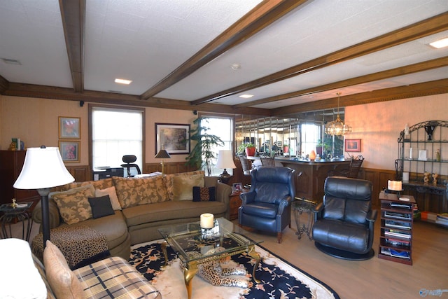 living area featuring beamed ceiling, wood finished floors, visible vents, and a notable chandelier