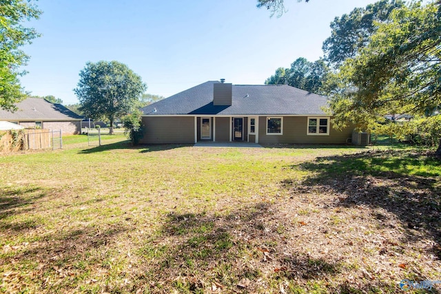 rear view of property featuring a yard and a patio area