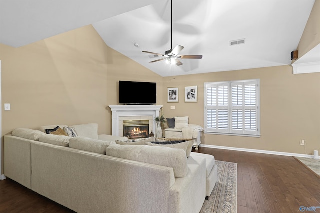 living area featuring visible vents, a ceiling fan, lofted ceiling, dark wood-style flooring, and a tile fireplace