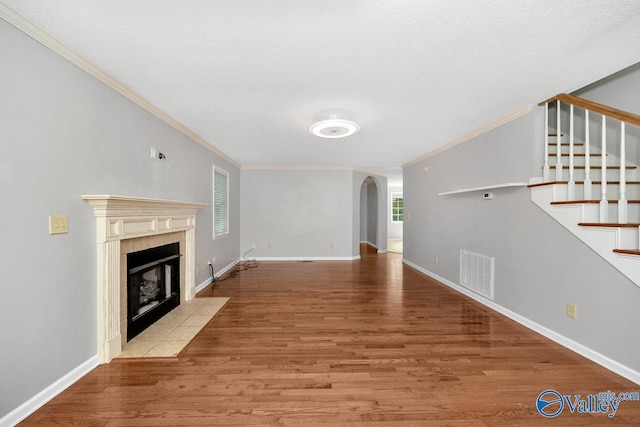 unfurnished living room featuring ornamental molding, a fireplace, and light hardwood / wood-style floors