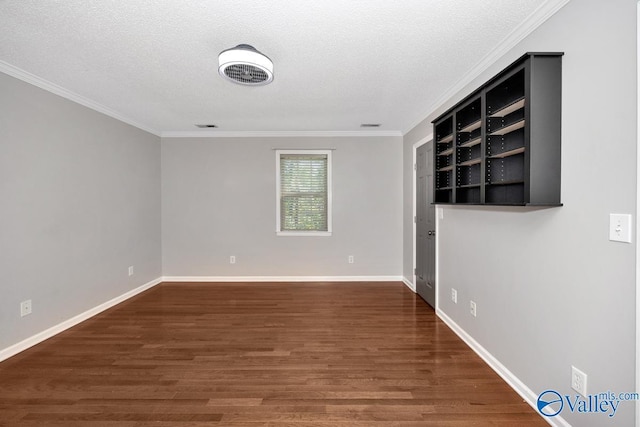 unfurnished room with dark wood-type flooring, ornamental molding, and a textured ceiling