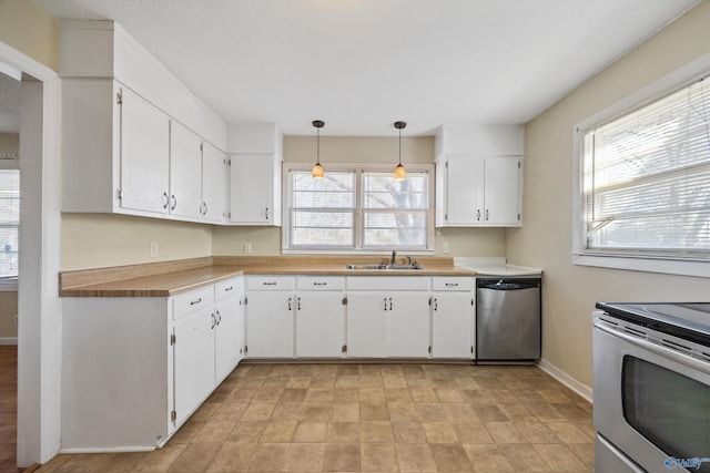 kitchen featuring hanging light fixtures, sink, white cabinets, and stainless steel appliances