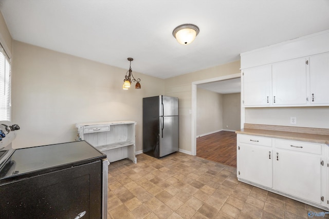 kitchen with decorative light fixtures, white cabinets, and appliances with stainless steel finishes