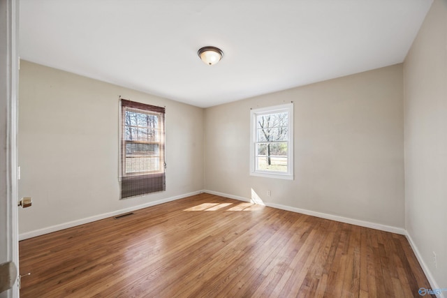 empty room featuring hardwood / wood-style flooring and plenty of natural light