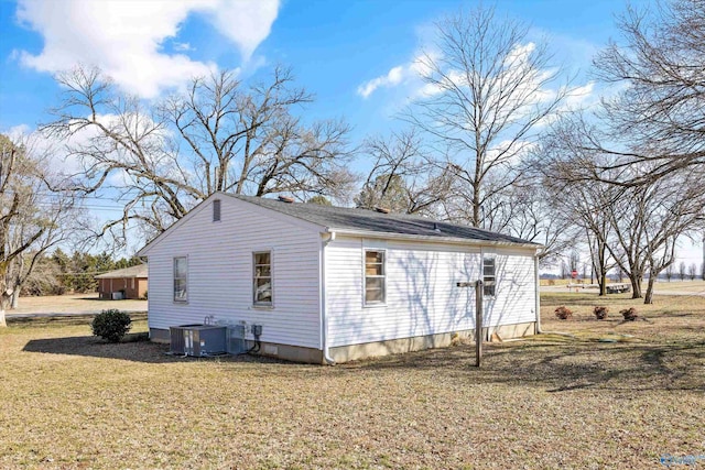 view of side of property featuring cooling unit and a lawn