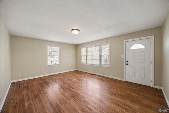 foyer entrance featuring dark wood-type flooring and a textured ceiling