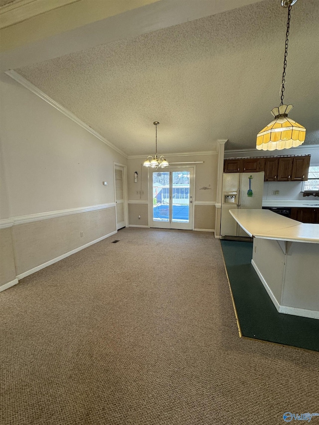 kitchen with ornamental molding, white refrigerator with ice dispenser, carpet flooring, light countertops, and a chandelier