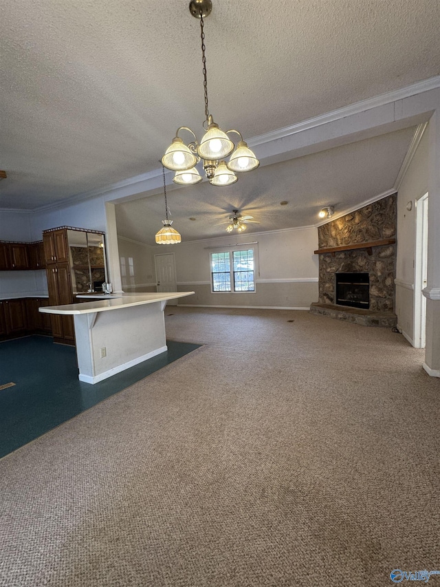 kitchen with a textured ceiling, a fireplace, light countertops, pendant lighting, and dark carpet