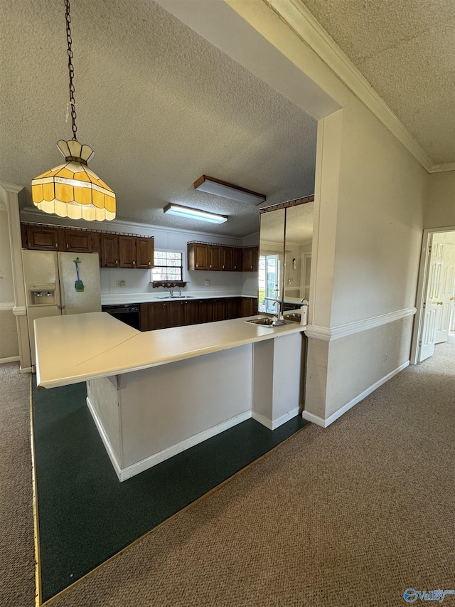 kitchen with a peninsula, ornamental molding, dark colored carpet, and a sink