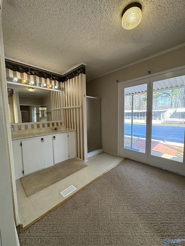 interior space featuring visible vents, plenty of natural light, a stall shower, and crown molding