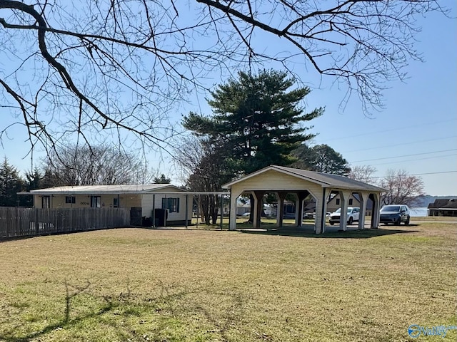 view of front facade featuring a gazebo, a carport, a front yard, and fence
