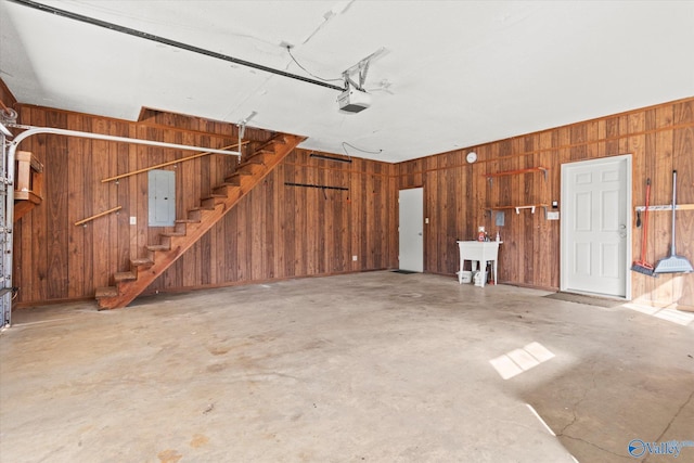 garage with a garage door opener, electric panel, and wooden walls