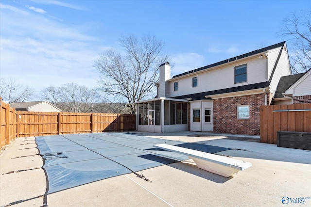 back of property with a patio area and a sunroom