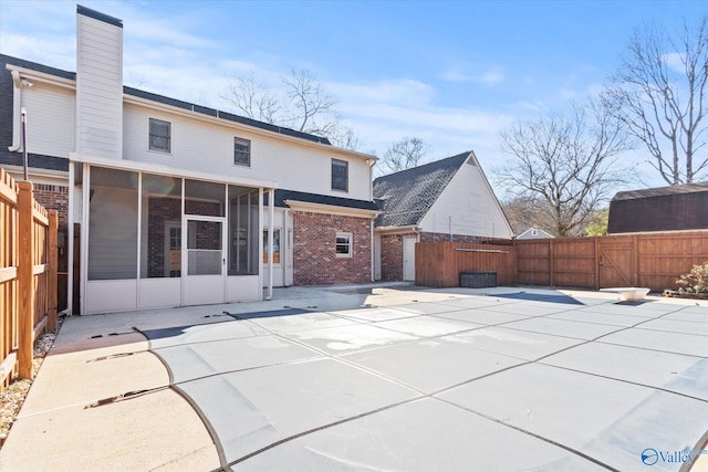 rear view of house featuring a patio area and a sunroom