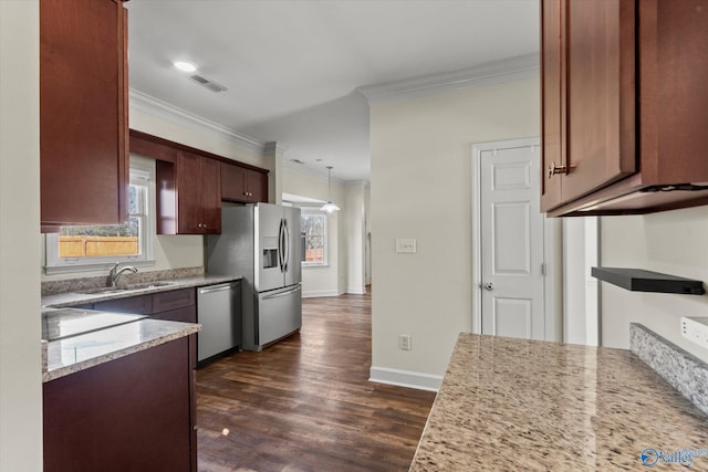 kitchen with decorative light fixtures, sink, light stone counters, and stainless steel appliances