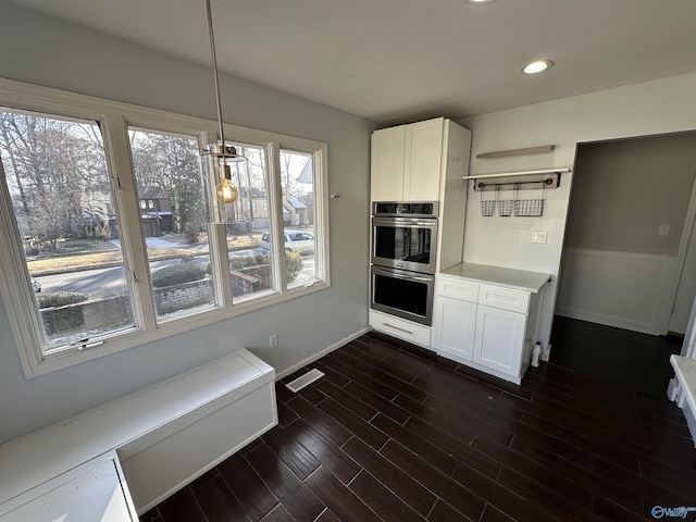 kitchen with open shelves, visible vents, dark wood-type flooring, stainless steel double oven, and white cabinetry