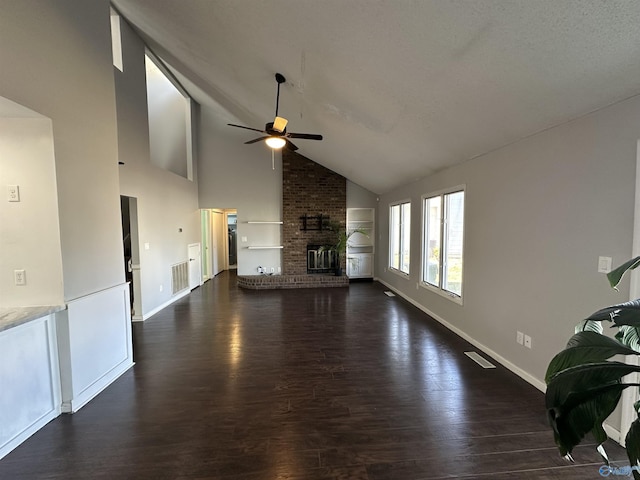 unfurnished living room with visible vents, a fireplace, a ceiling fan, and dark wood-type flooring