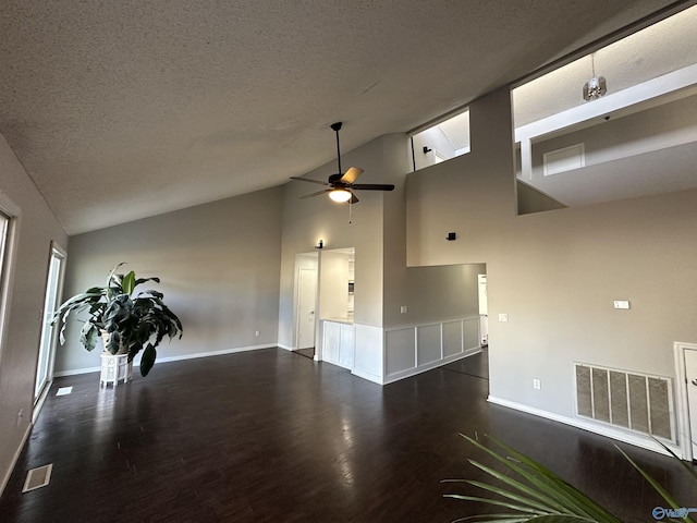 unfurnished room featuring lofted ceiling, a textured ceiling, visible vents, and dark wood-type flooring