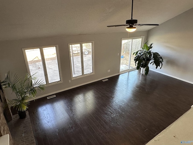 unfurnished room featuring baseboards, plenty of natural light, visible vents, and wood finished floors