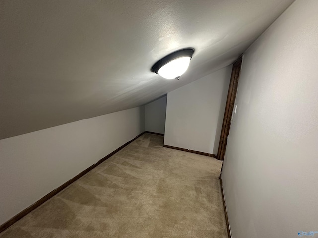 bonus room featuring light carpet, baseboards, and lofted ceiling