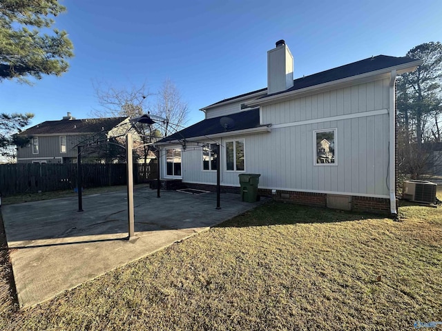 back of property with a patio, fence, crawl space, a lawn, and a chimney