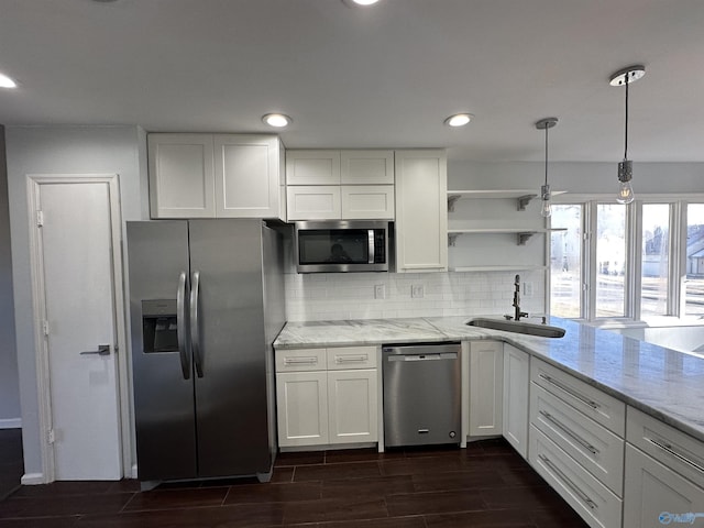 kitchen featuring stainless steel appliances, white cabinetry, a sink, and open shelves