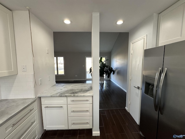 kitchen with tasteful backsplash, wood tiled floor, white cabinetry, and stainless steel fridge with ice dispenser