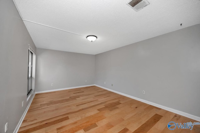 spare room with wood-type flooring and a textured ceiling