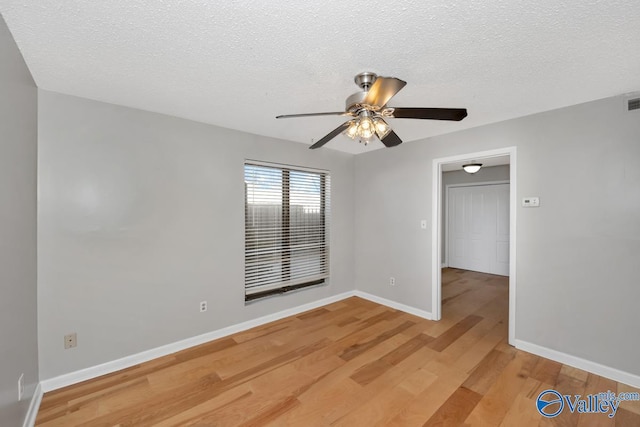 unfurnished room featuring hardwood / wood-style floors, ceiling fan, and a textured ceiling