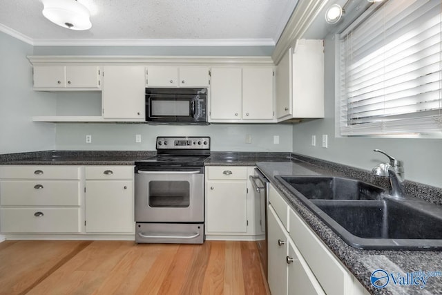 kitchen featuring white cabinets, a textured ceiling, stainless steel appliances, and sink