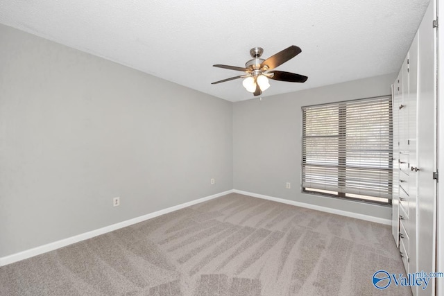 carpeted spare room with a textured ceiling and ceiling fan