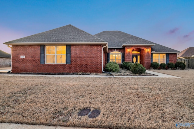 ranch-style home with a yard