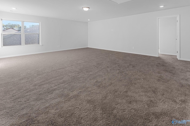 spare room featuring attic access, dark colored carpet, baseboards, and recessed lighting