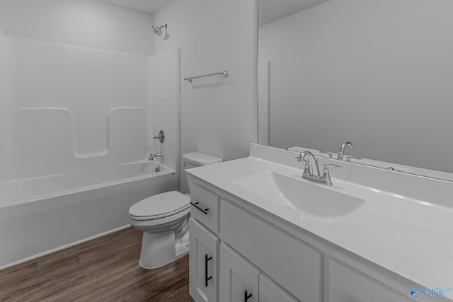 bathroom with toilet, vanity, wood finished floors, and shower / tub combination