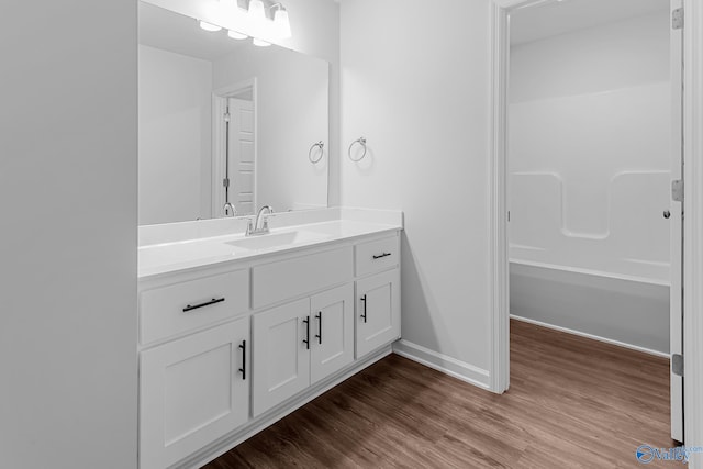 bathroom with vanity, hardwood / wood-style flooring, and  shower combination