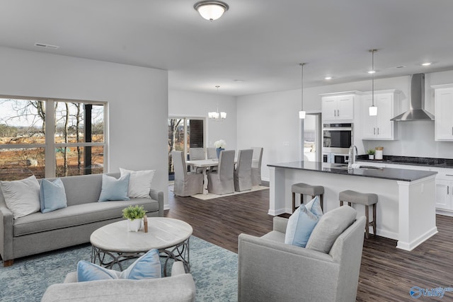 living room with an inviting chandelier, visible vents, dark wood-style flooring, and recessed lighting