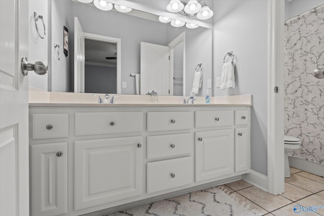 bathroom with tile patterned flooring, ornamental molding, and vanity