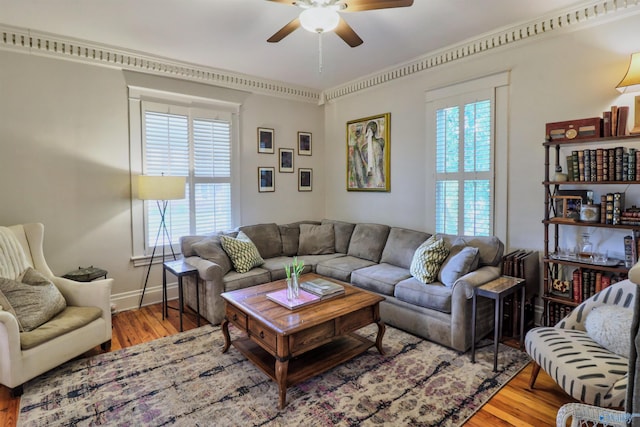 living room with baseboards, ceiling fan, and wood finished floors