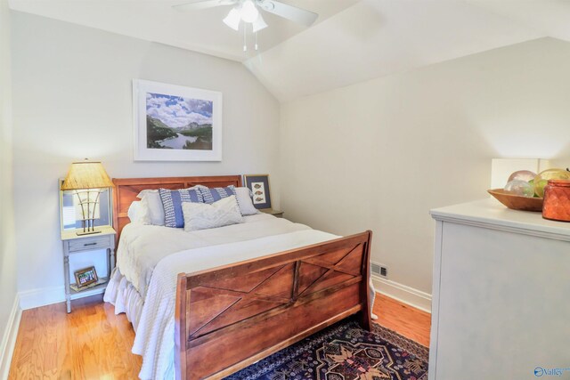 bedroom with baseboards, wood finished floors, a ceiling fan, and vaulted ceiling