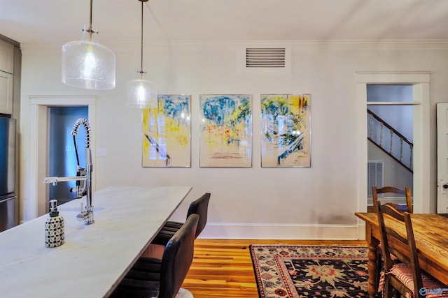 dining room featuring ornamental molding and hardwood / wood-style floors