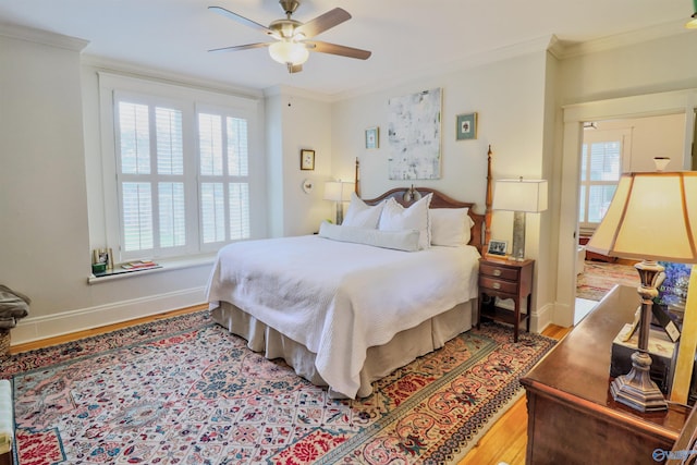 bedroom featuring multiple windows, hardwood / wood-style flooring, ceiling fan, and crown molding