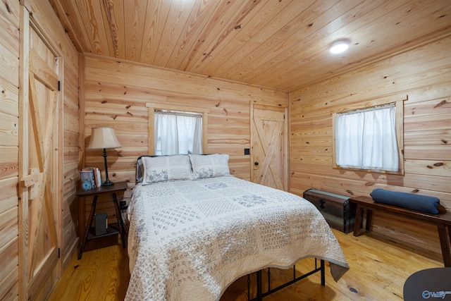 bedroom featuring wooden ceiling, wooden walls, and light hardwood / wood-style floors