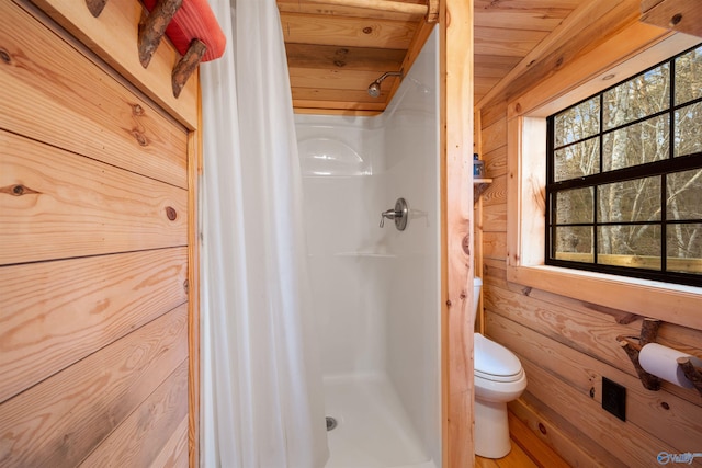 bathroom with wood walls, toilet, wooden ceiling, and walk in shower