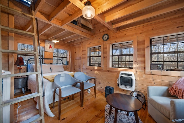 sitting room with wood ceiling, heating unit, wooden walls, lofted ceiling with beams, and light hardwood / wood-style floors