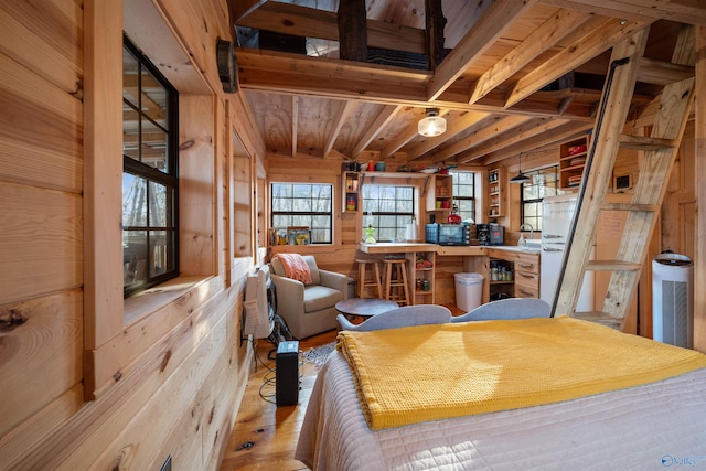 bedroom with light wood-type flooring and wood walls