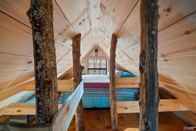 unfurnished bedroom with wood walls, wood-type flooring, and vaulted ceiling